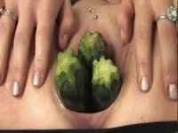 Brunette keeps her thighs open while stuffing cunt with many veggies in this insertion scene